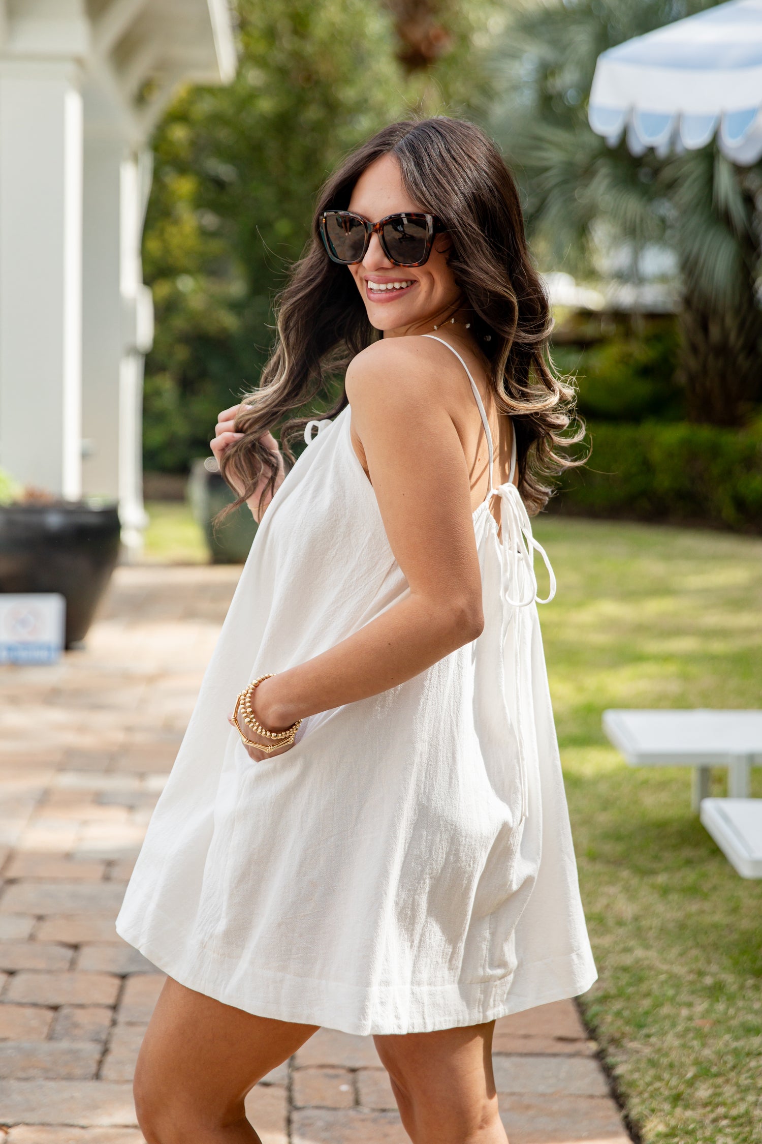 Woman in a white dress standing outdoors on a sunny day