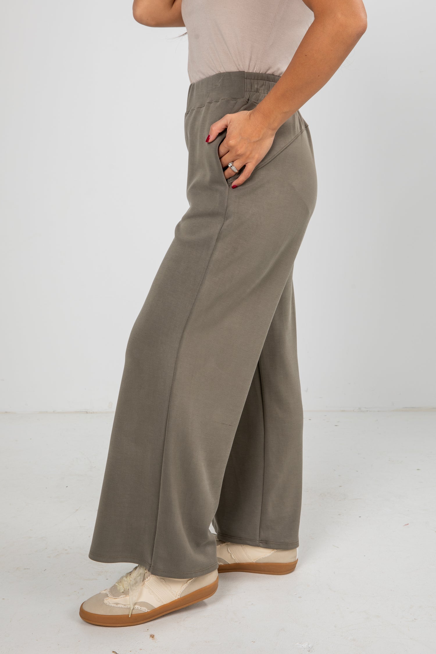 Person wearing gray wide-leg pants on a white background
