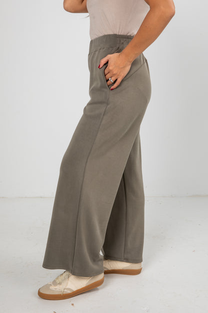 Person wearing gray wide-leg pants on a white background
