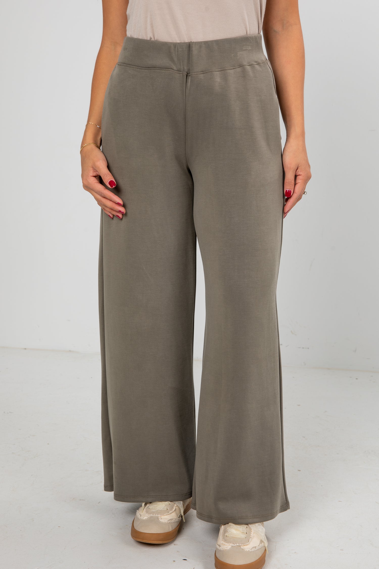 Person wearing brown wide-leg pants on a white background
