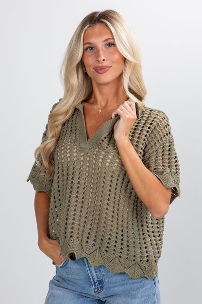 Woman wearing a green knitted sweater against a white background