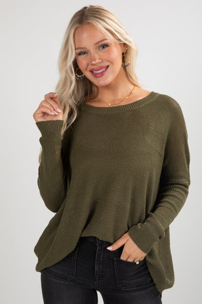 Woman wearing an olive green sweater against a white background