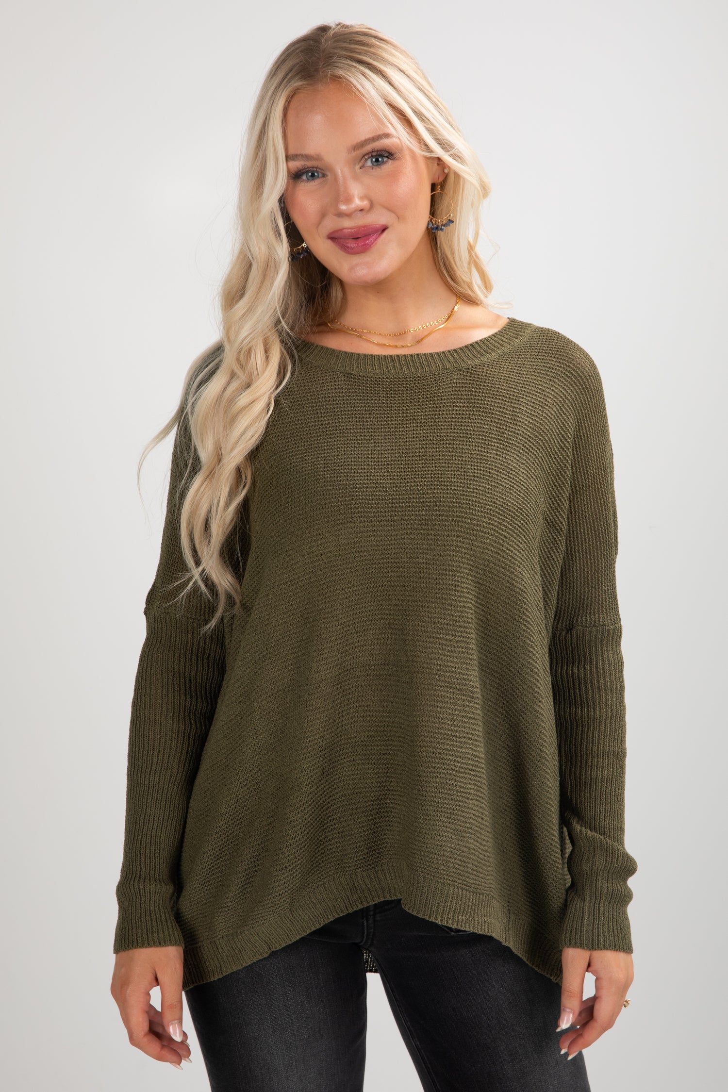 Woman wearing an olive green sweater against a white background