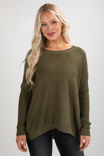 Woman wearing an olive green sweater against a white background