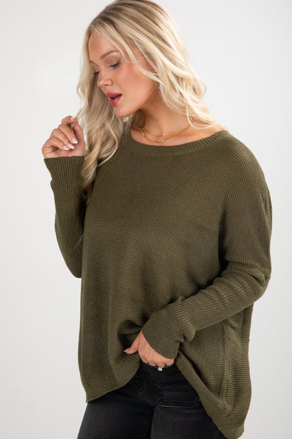Woman wearing an olive green sweater against a white background