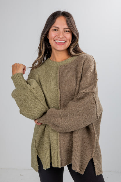 Woman wearing a green and brown sweater against a white background