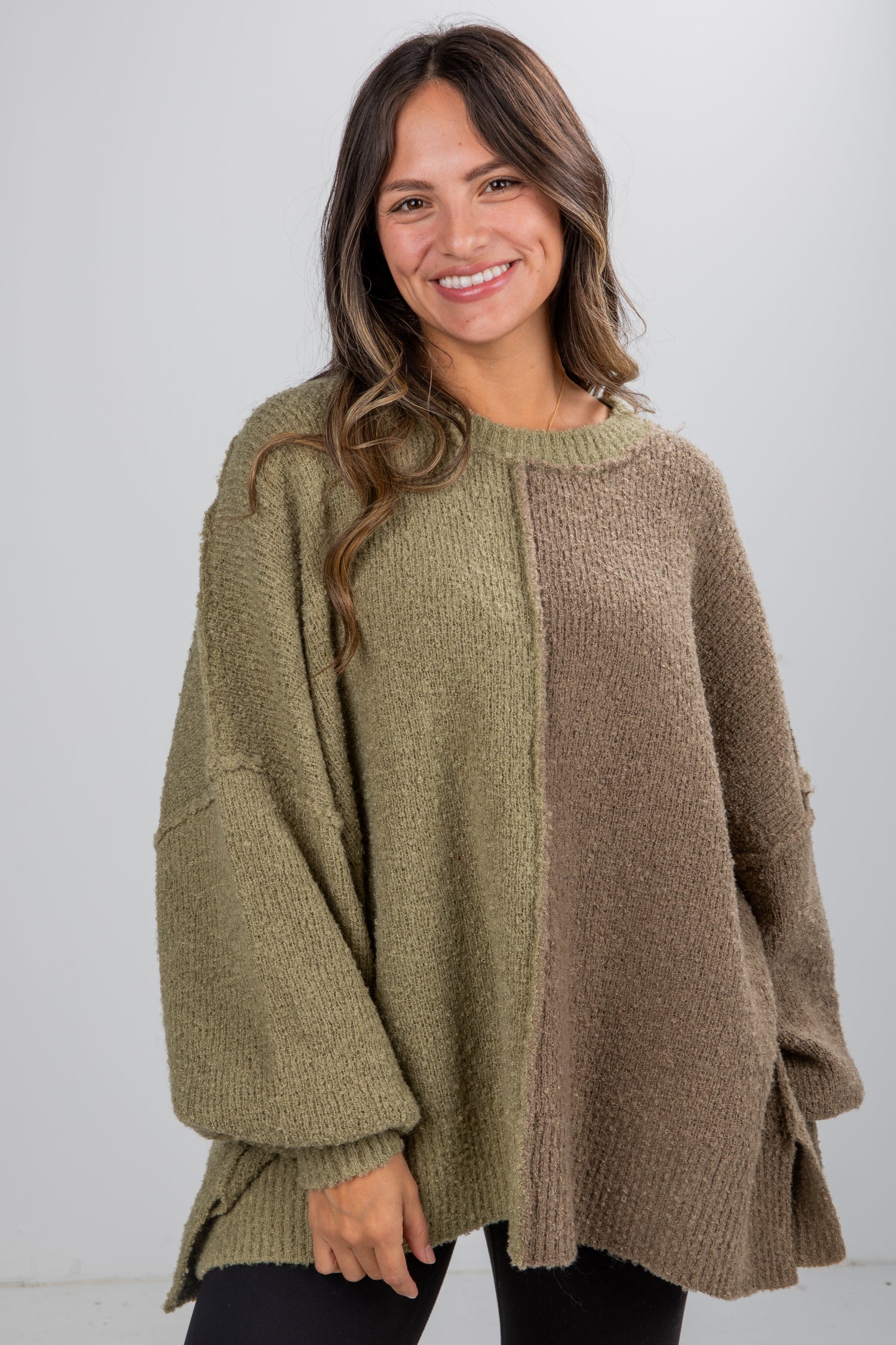 Woman wearing a green and brown sweater with a white background