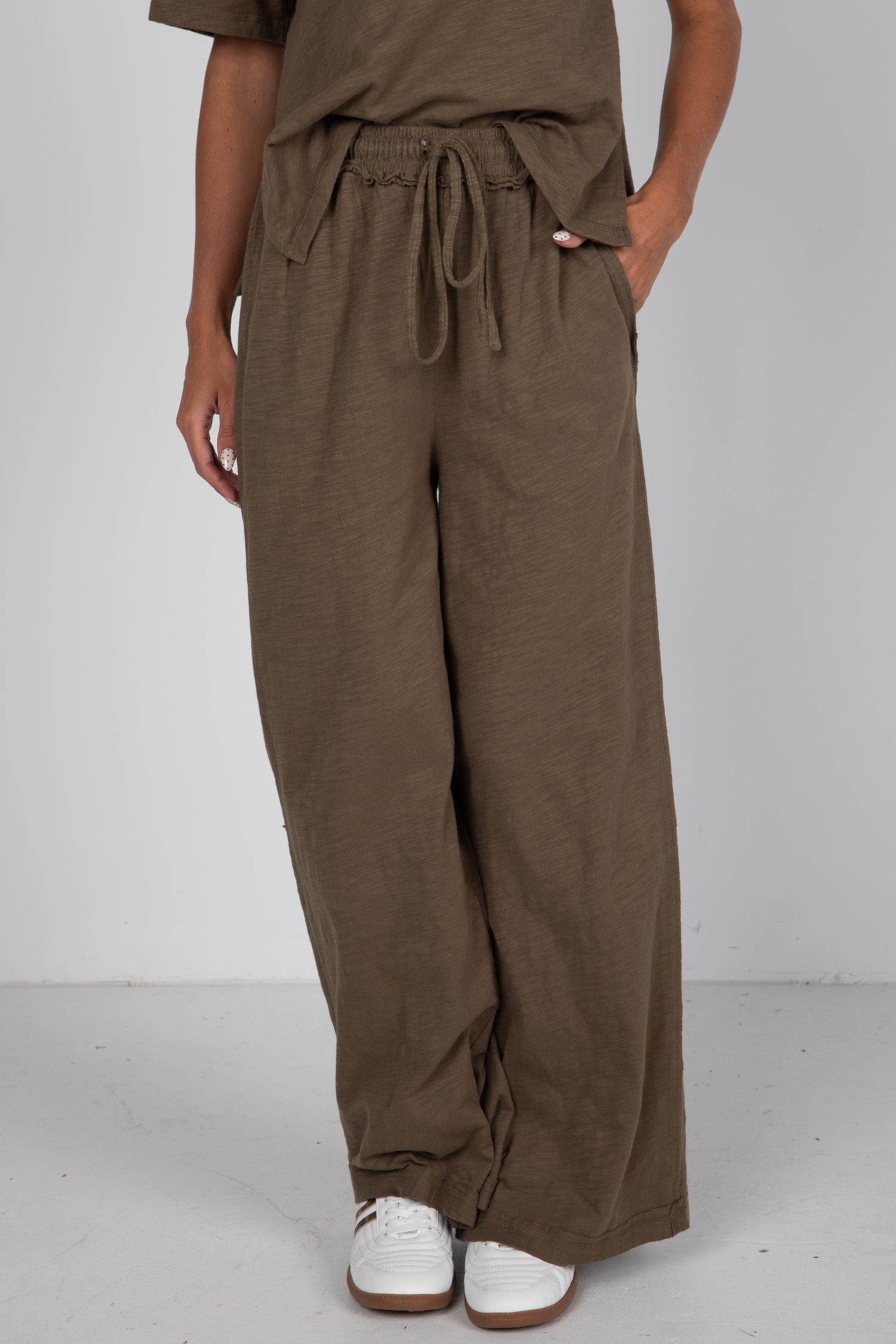 Brown wide-leg pants worn by a person on a white background