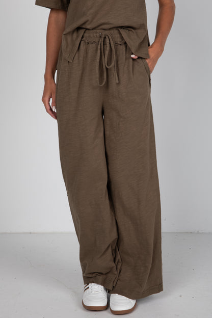 Brown wide-leg pants worn by a person on a white background