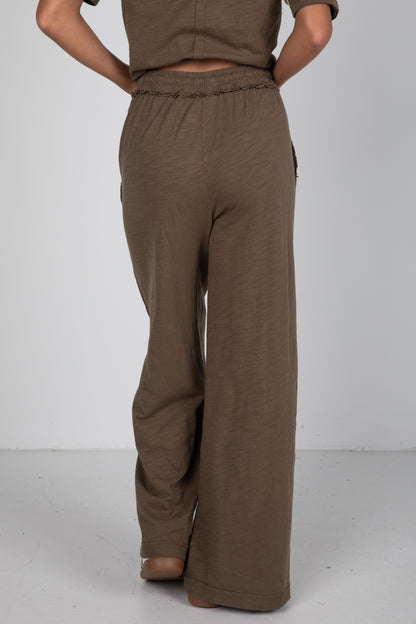 Brown pants worn by a person on a white background