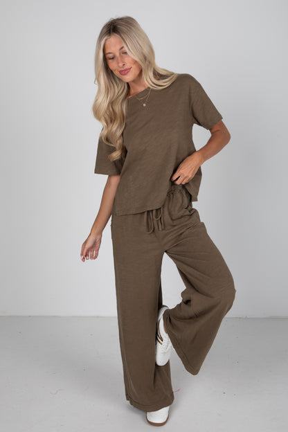 Woman wearing a brown outfit on a plain background