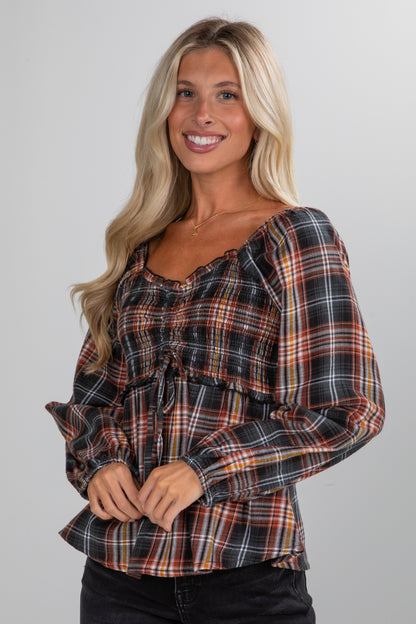 Woman wearing a plaid shirt against a plain background