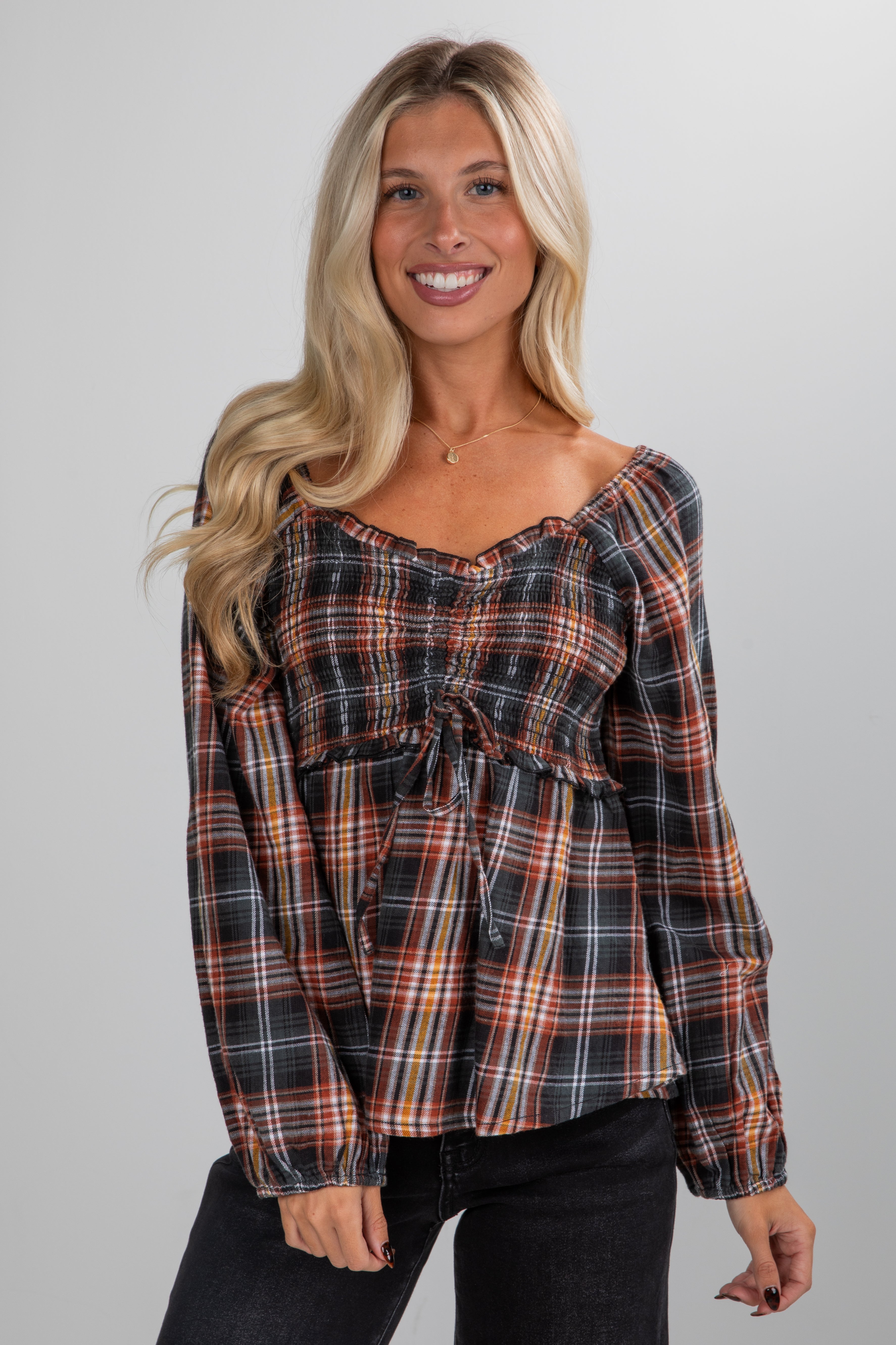Woman wearing a plaid top against a plain background