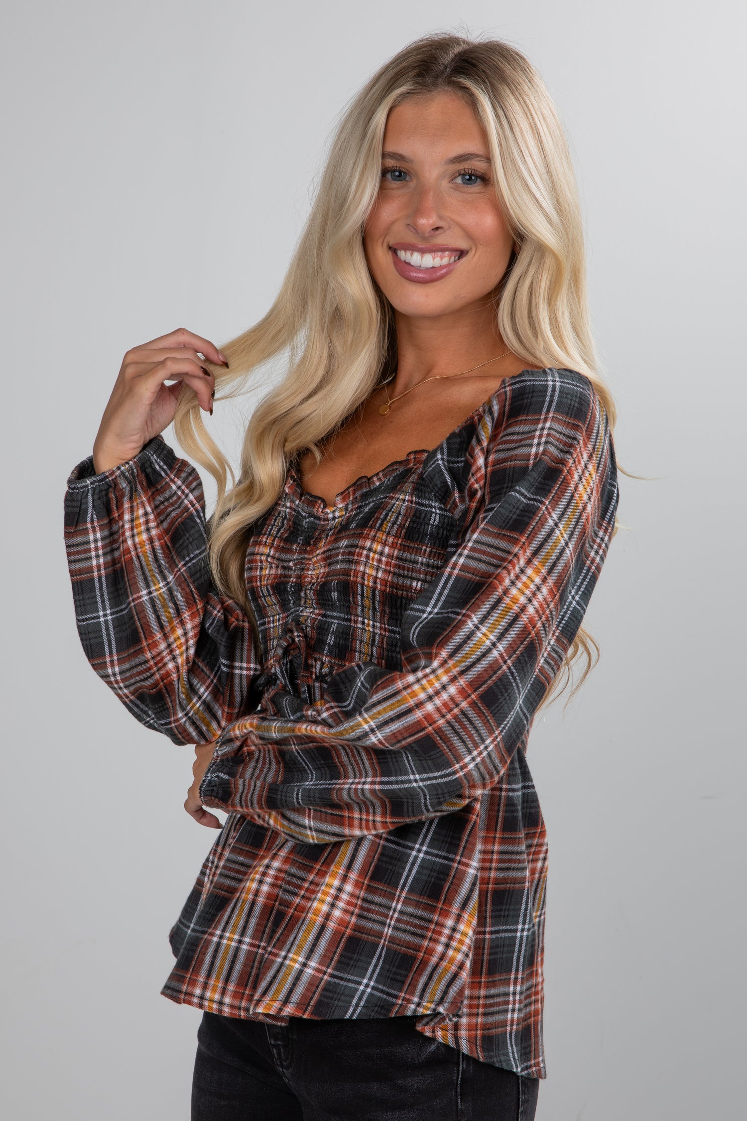 Woman wearing a plaid blouse against a plain background