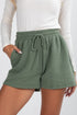 Green shorts worn by a person on a white background