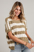 A woman wearing a short-sleeve knit sweater with horizontal stripes in tan and off-white, paired with light blue jeans, against a light gray paneled wall.