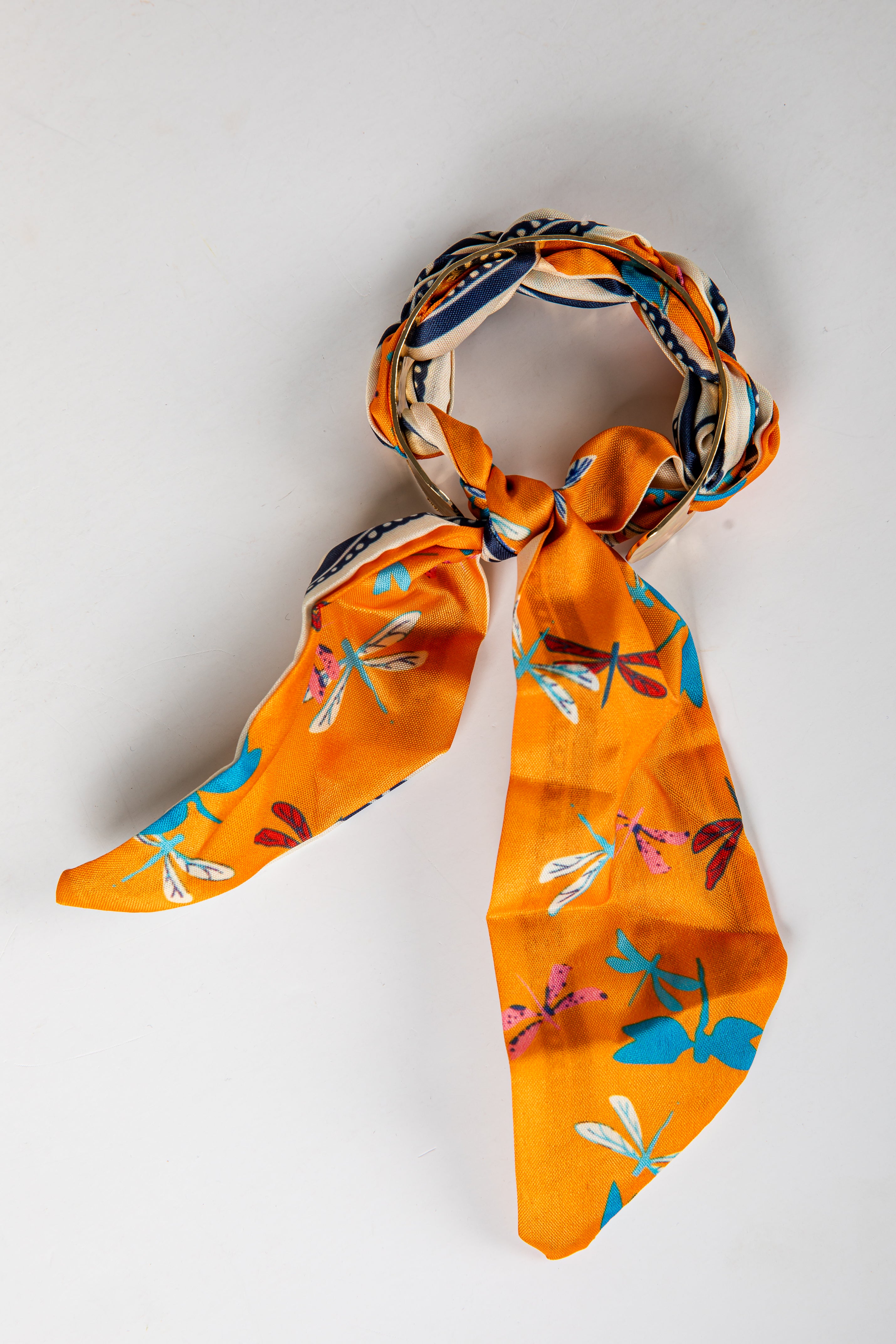Orange scarf with dragonfly pattern on a light gray background
