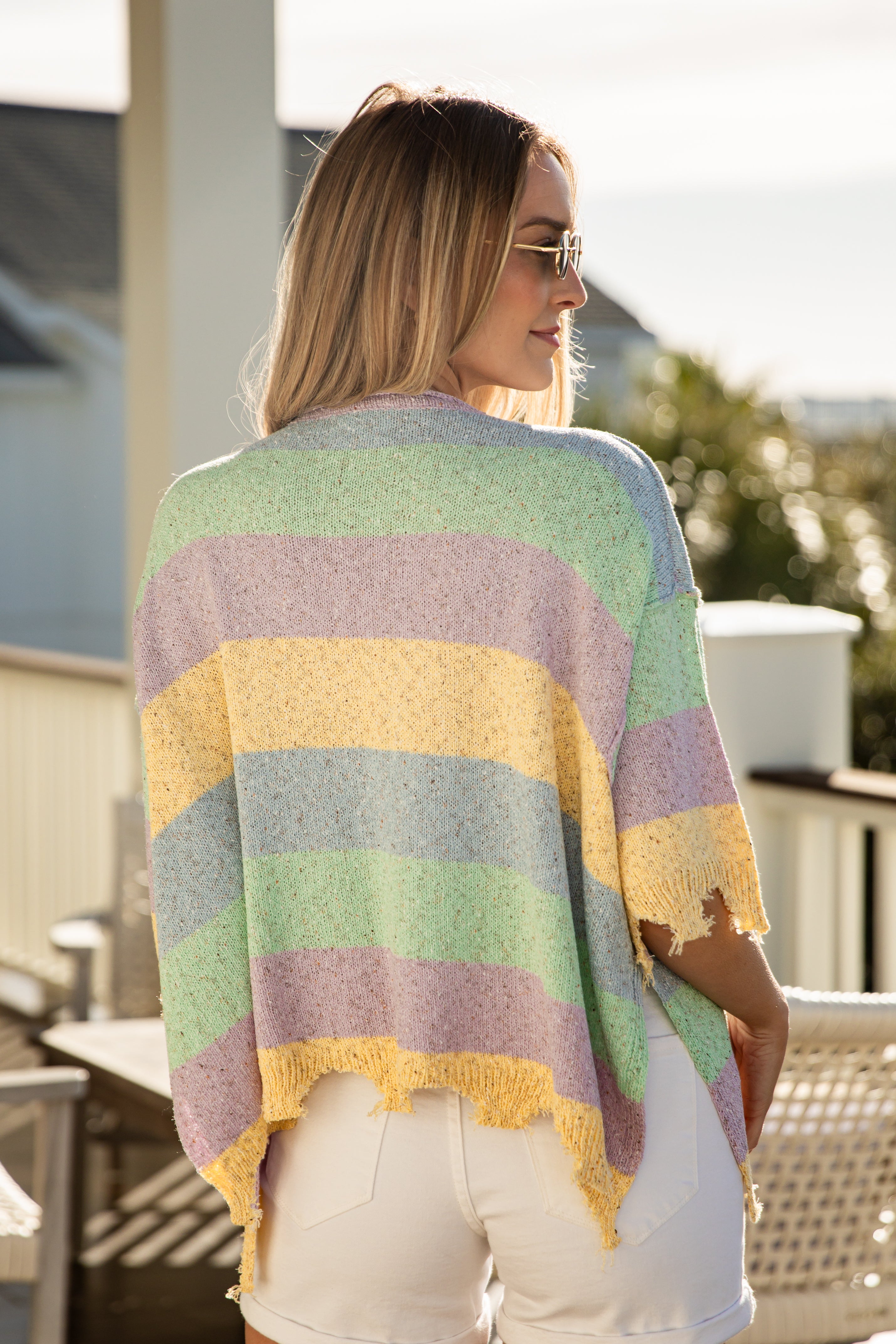 Woman wearing a colorful striped sweater on a balcony