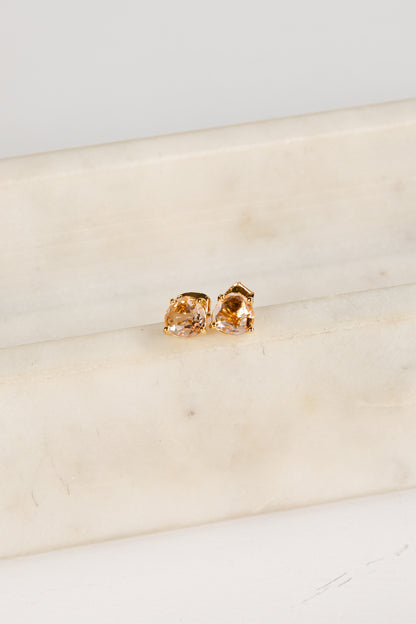 Gold earrings on a marble surface