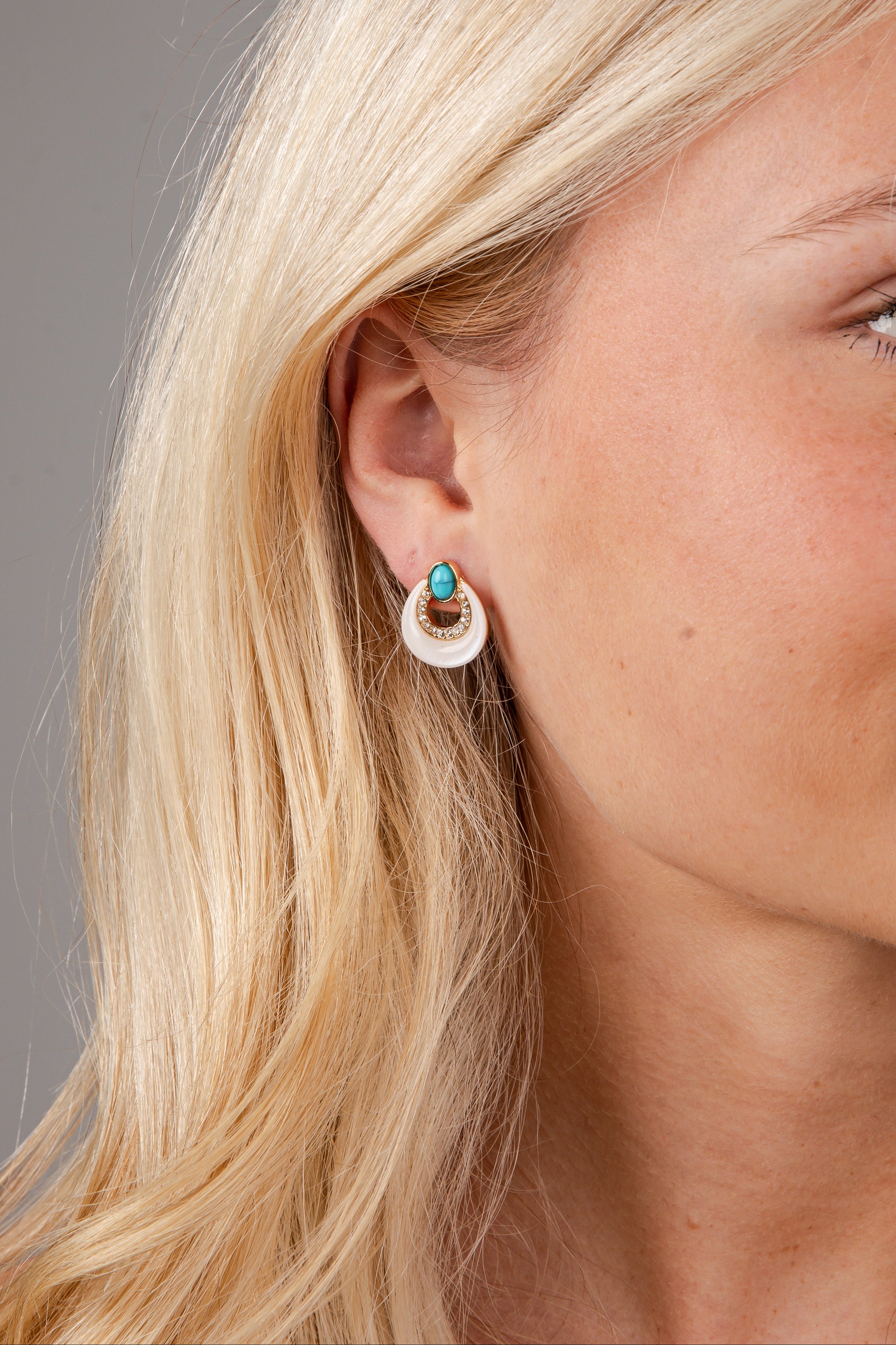 Close-up of a woman wearing earrings with a neutral background