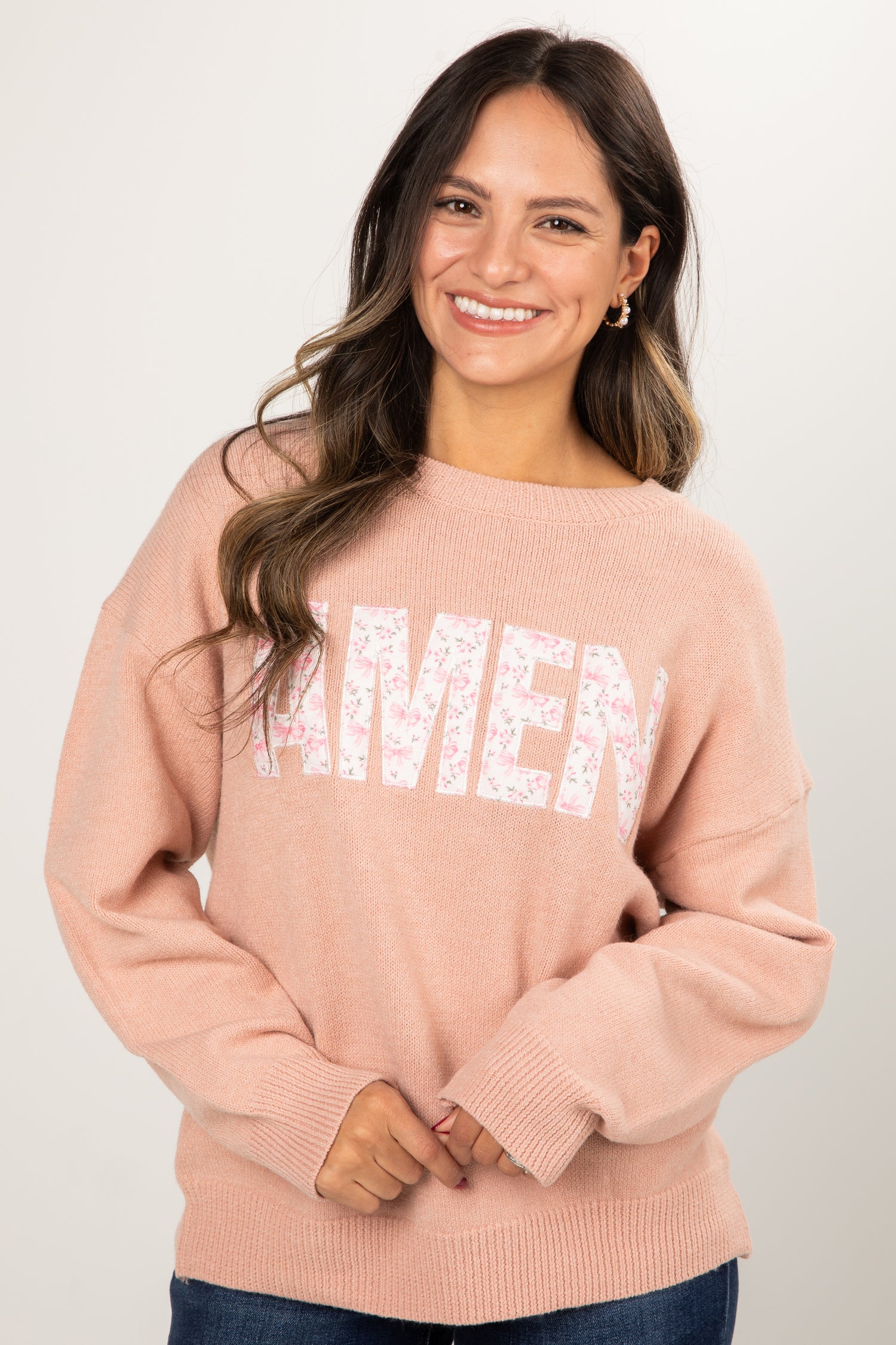 Woman wearing a pink sweater with &