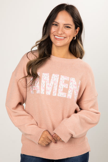 Woman wearing a pink sweater with &