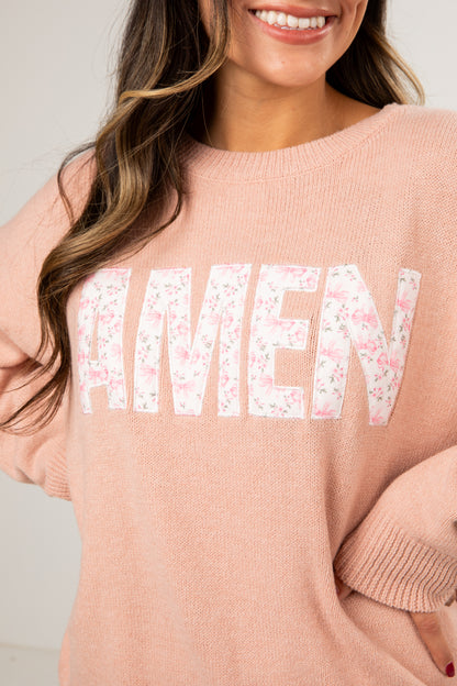 Person wearing a pink sweater with &