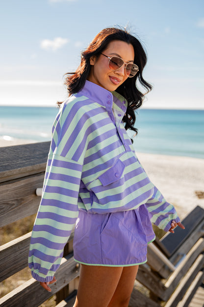 Woman wearing a striped shirt and shorts by the beach