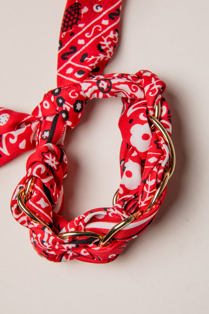 Red patterned headband with gold chain on a light background