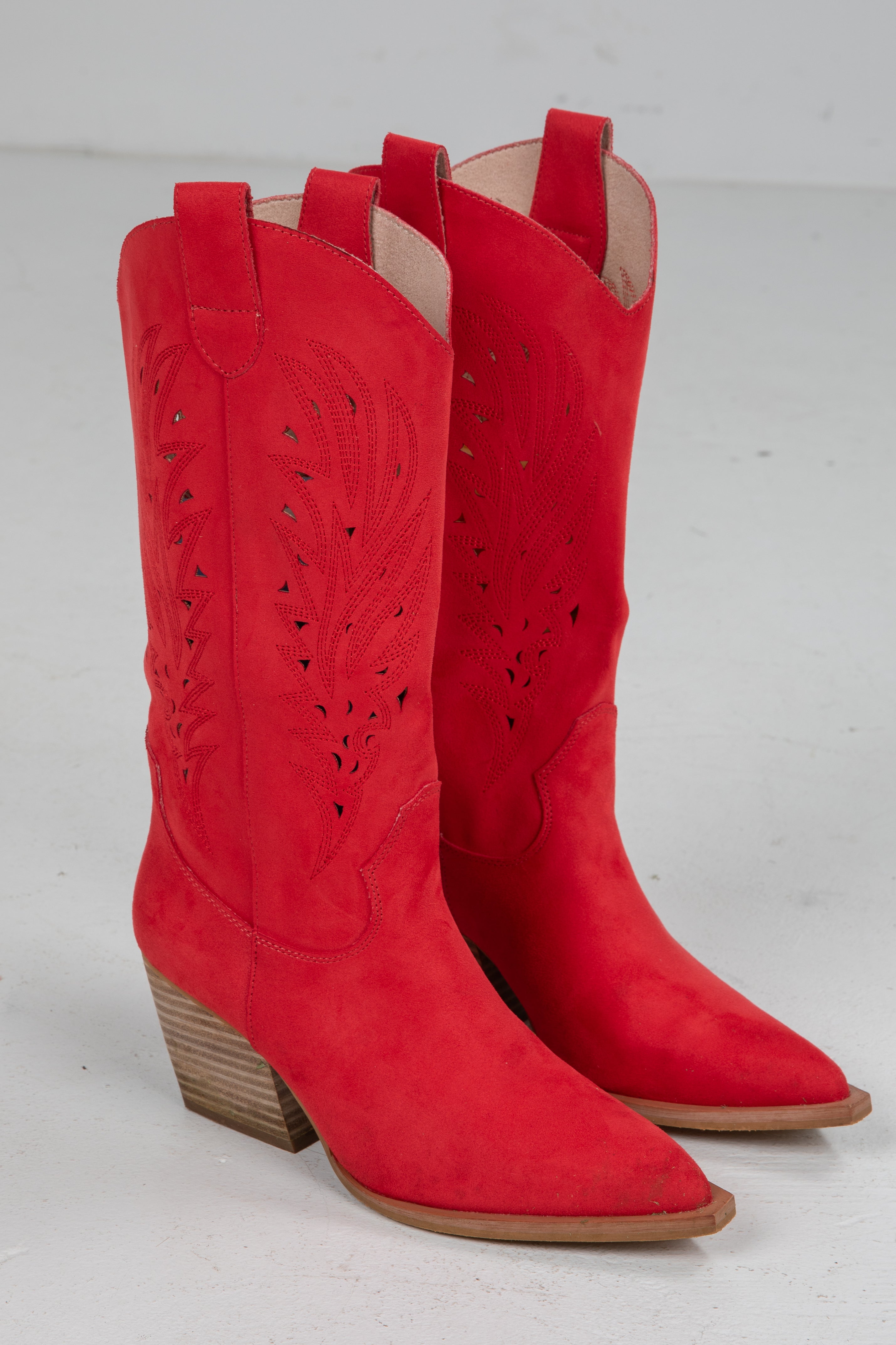 Pair of red cowboy boots on a light gray background