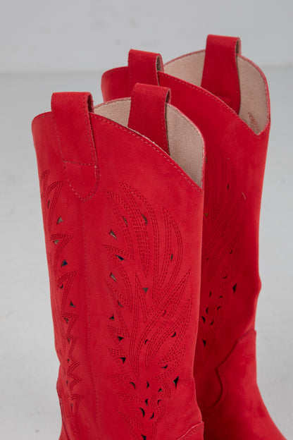 Close-up of red cowboy boots with cut-out design on a gray background