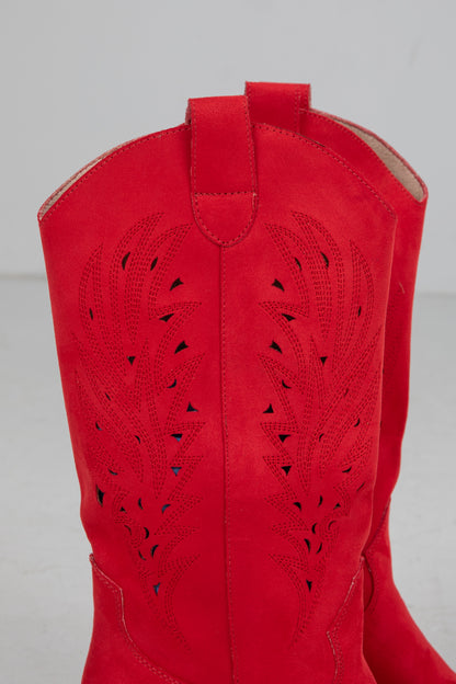 Red cowboy boot with cut-out design on a gray background