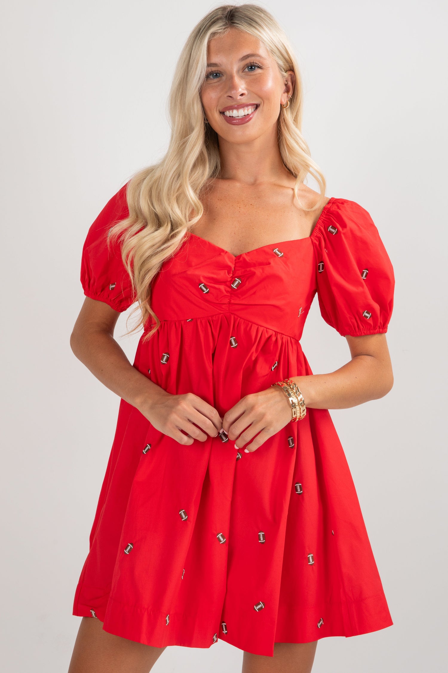 Woman wearing a red dress with puff sleeves on a white background