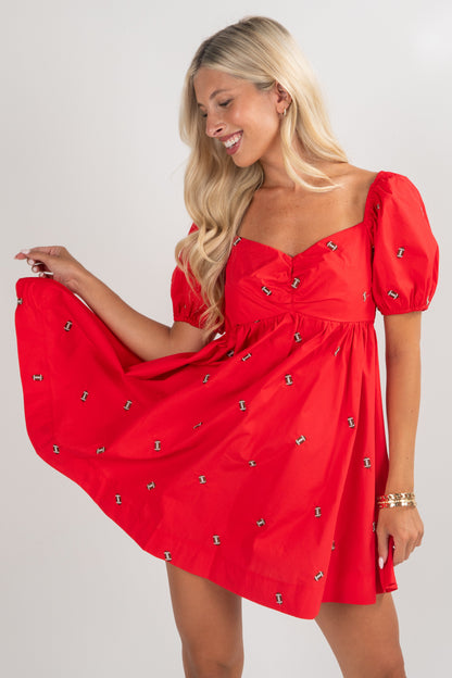 Woman wearing a red dress with puff sleeves on a white background