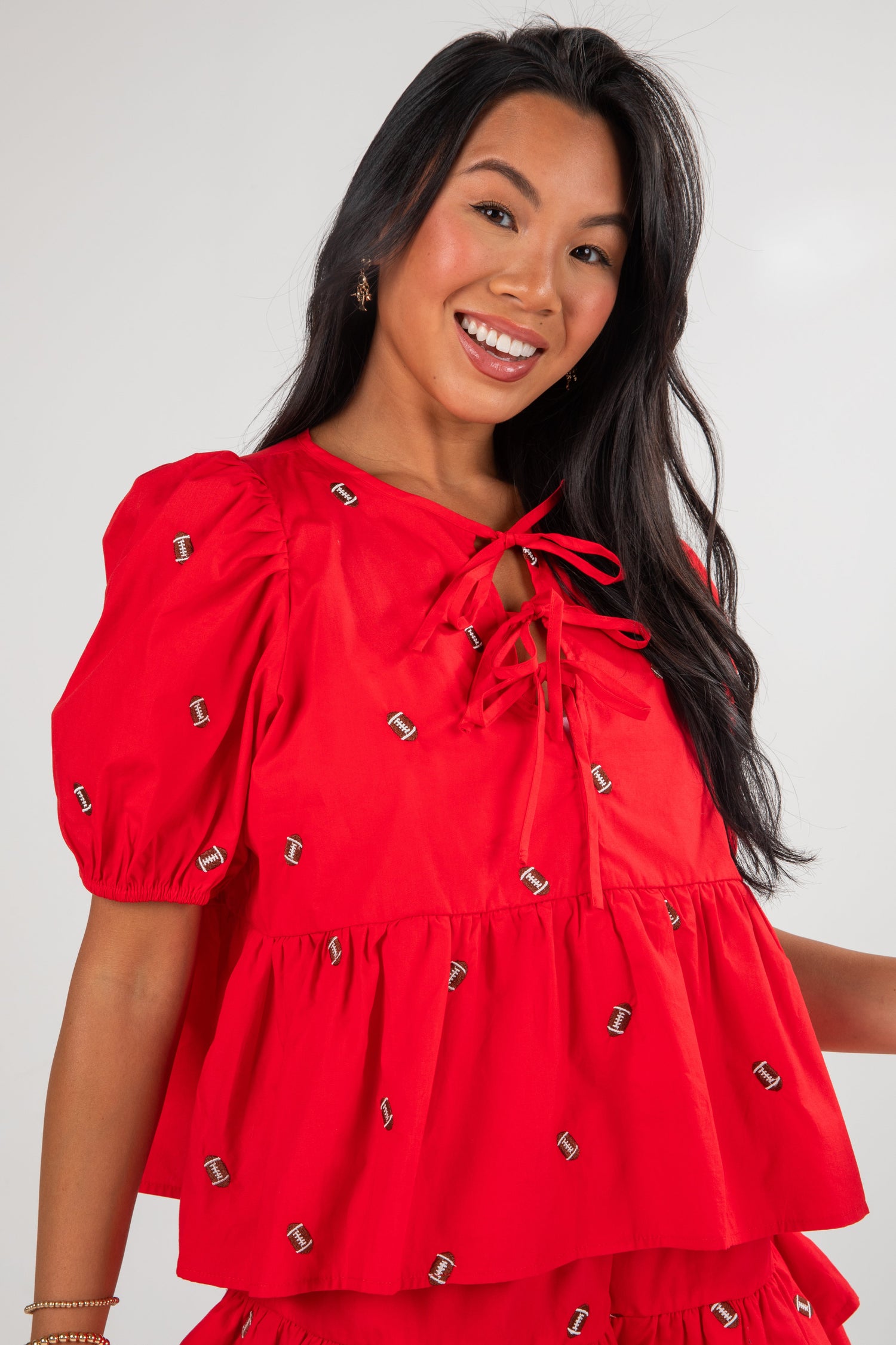 Woman wearing a red dress with puff sleeves and decorative elements on a white background
