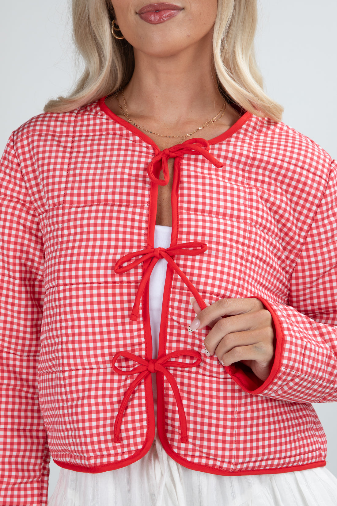 Red and white checkered jacket with a tie front on a plain background