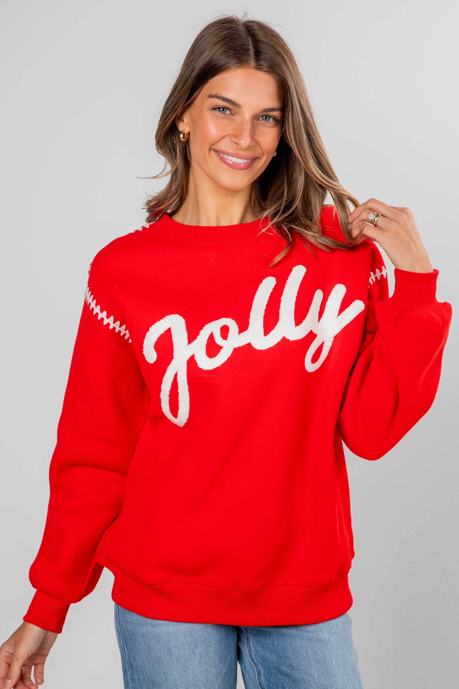 Woman wearing a red sweater with &