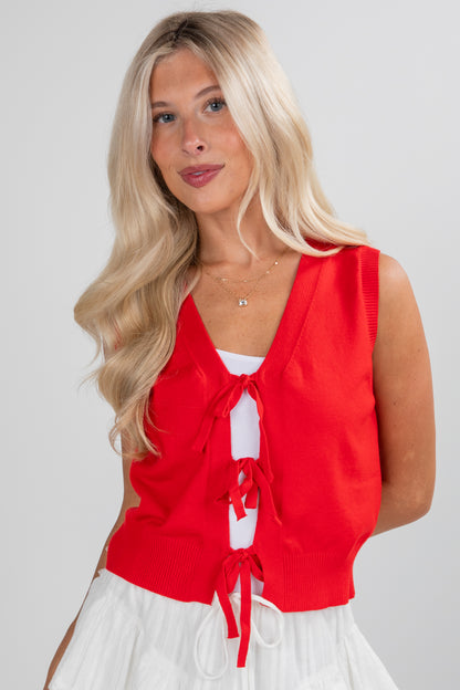 Woman wearing a red sleeveless top with a white background