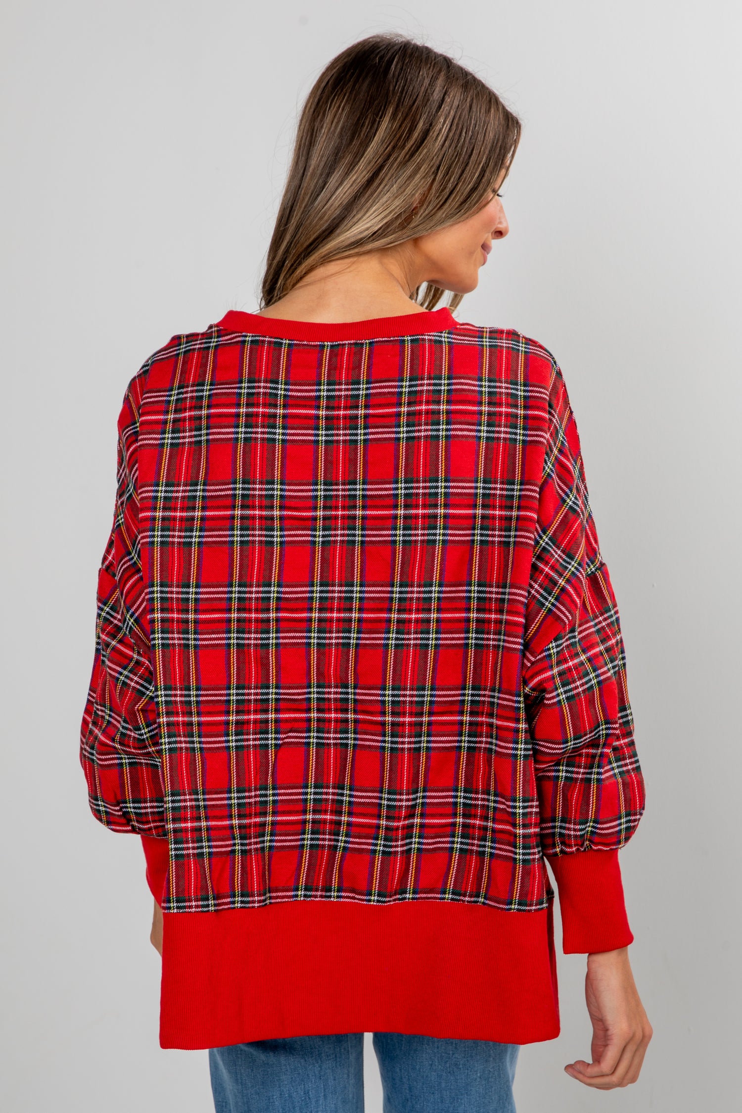 Red plaid shirt worn by a person on a gray background