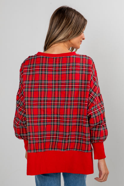 Red plaid shirt worn by a person on a gray background