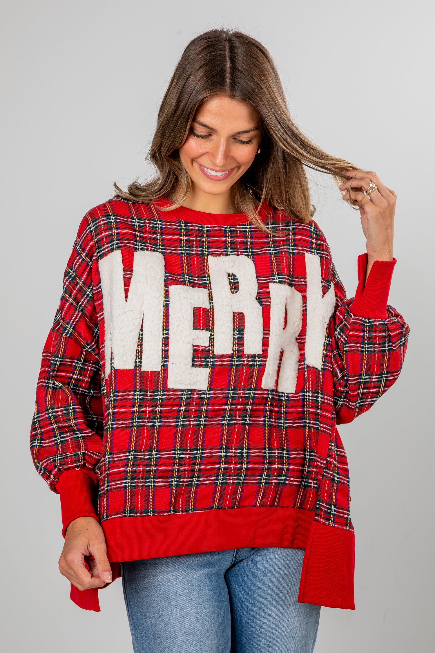 Woman wearing a red plaid sweater with &