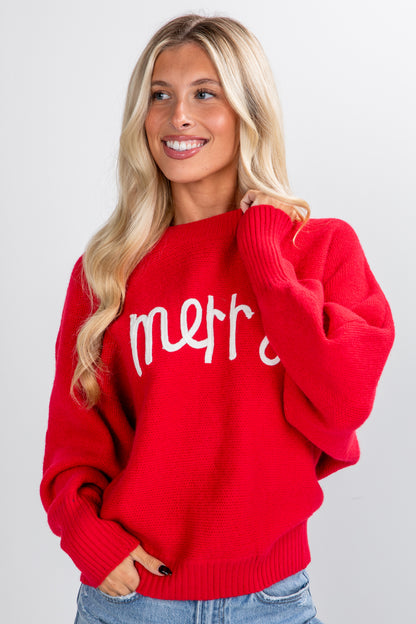 Woman wearing a red sweater with &