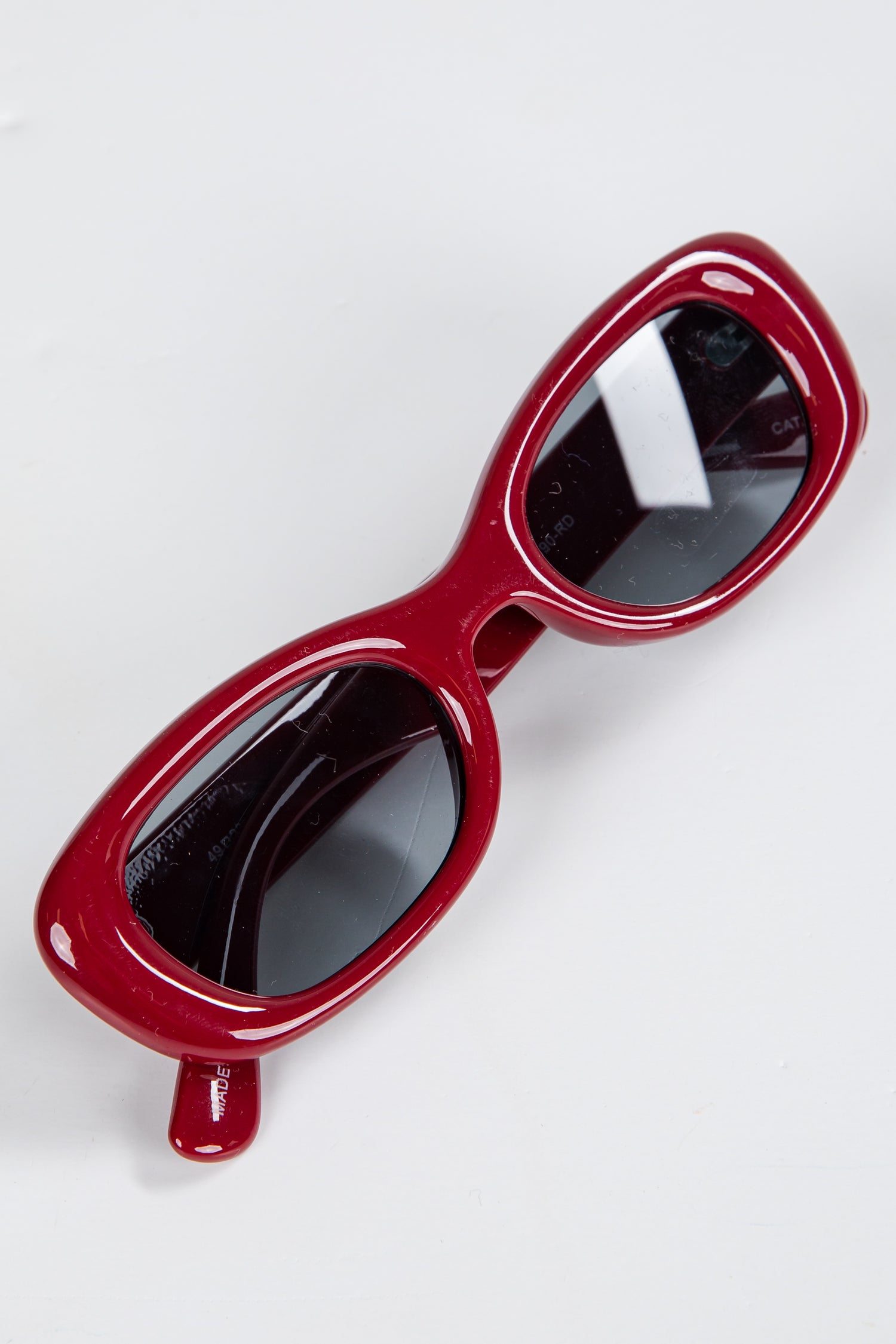 Red sunglasses with black lenses on a white background