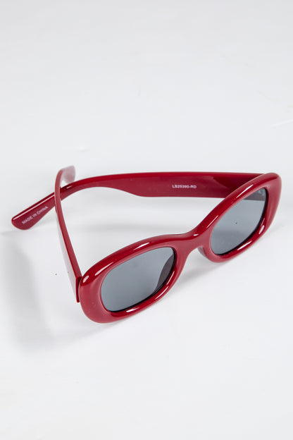Red sunglasses with dark lenses on a white background