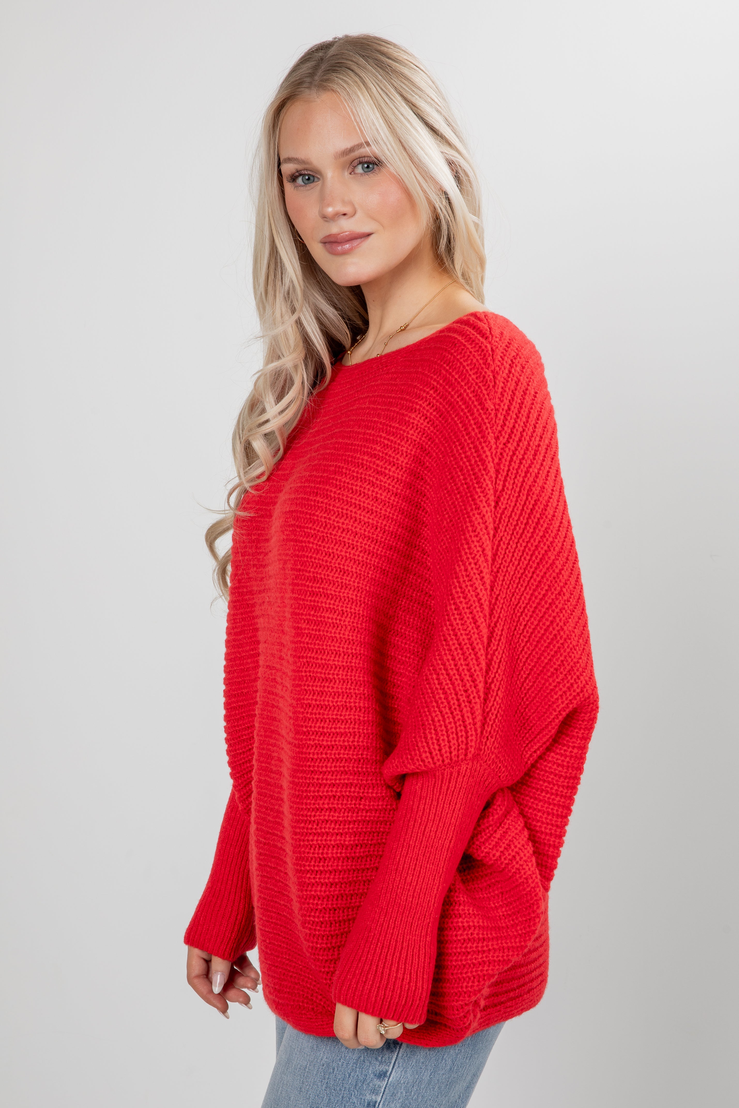Woman wearing a red sweater on a gray background