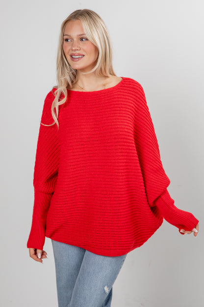 Woman wearing a red sweater against a plain background