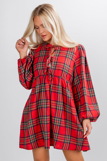 Woman wearing a red plaid dress on a gray background