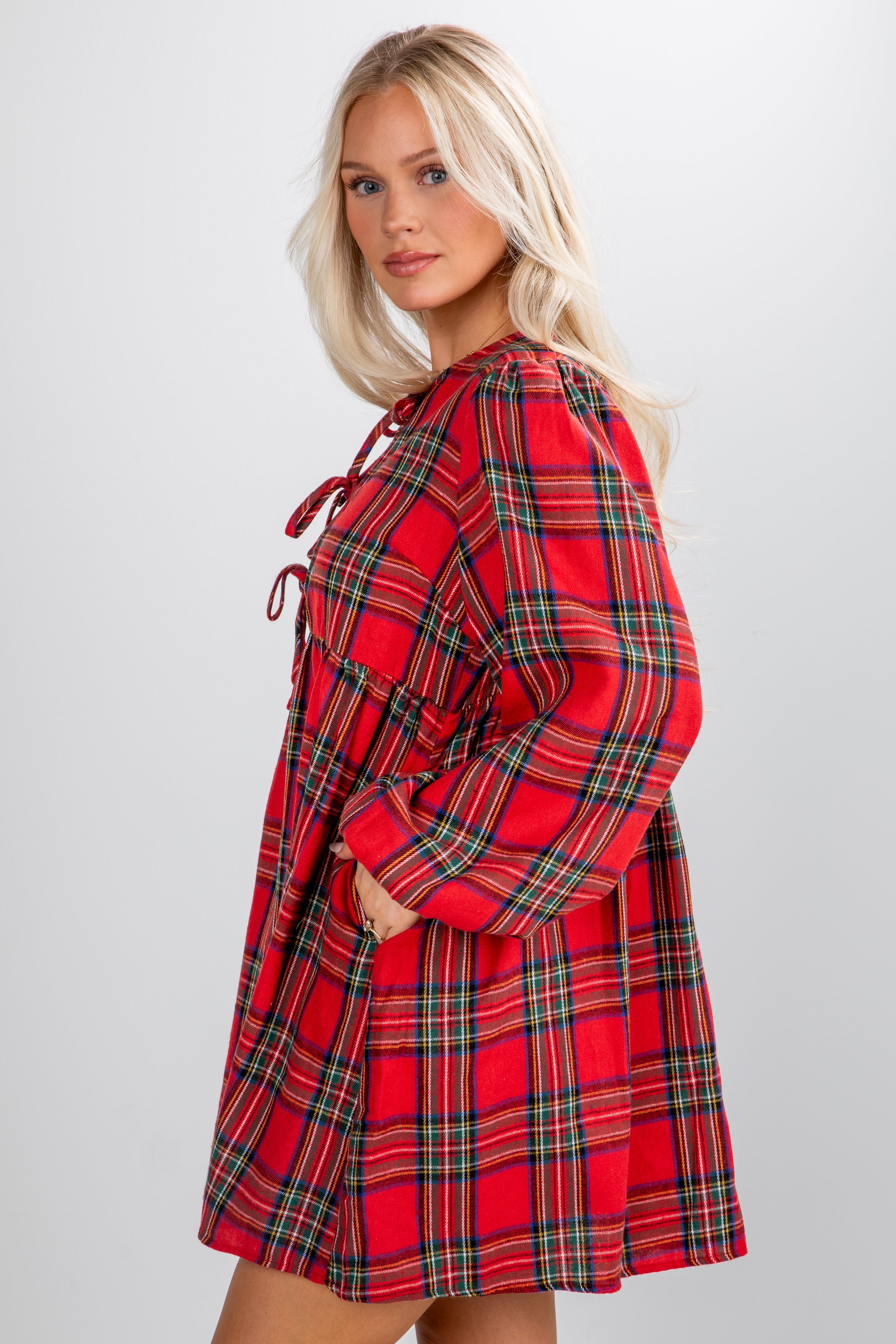 Woman wearing a red plaid dress against a white background