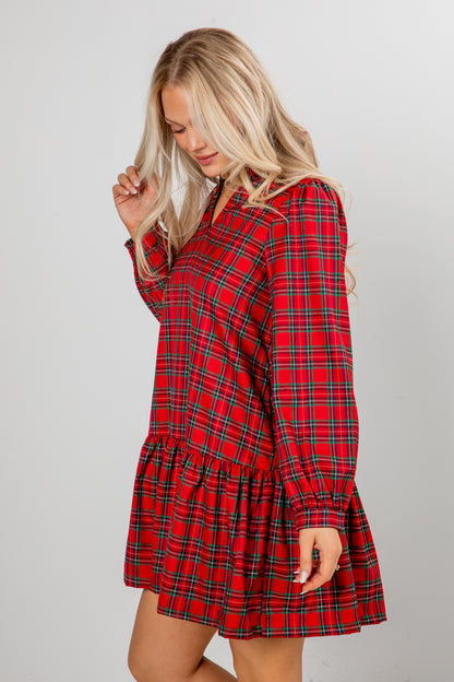 Woman wearing a red plaid dress against a gray background