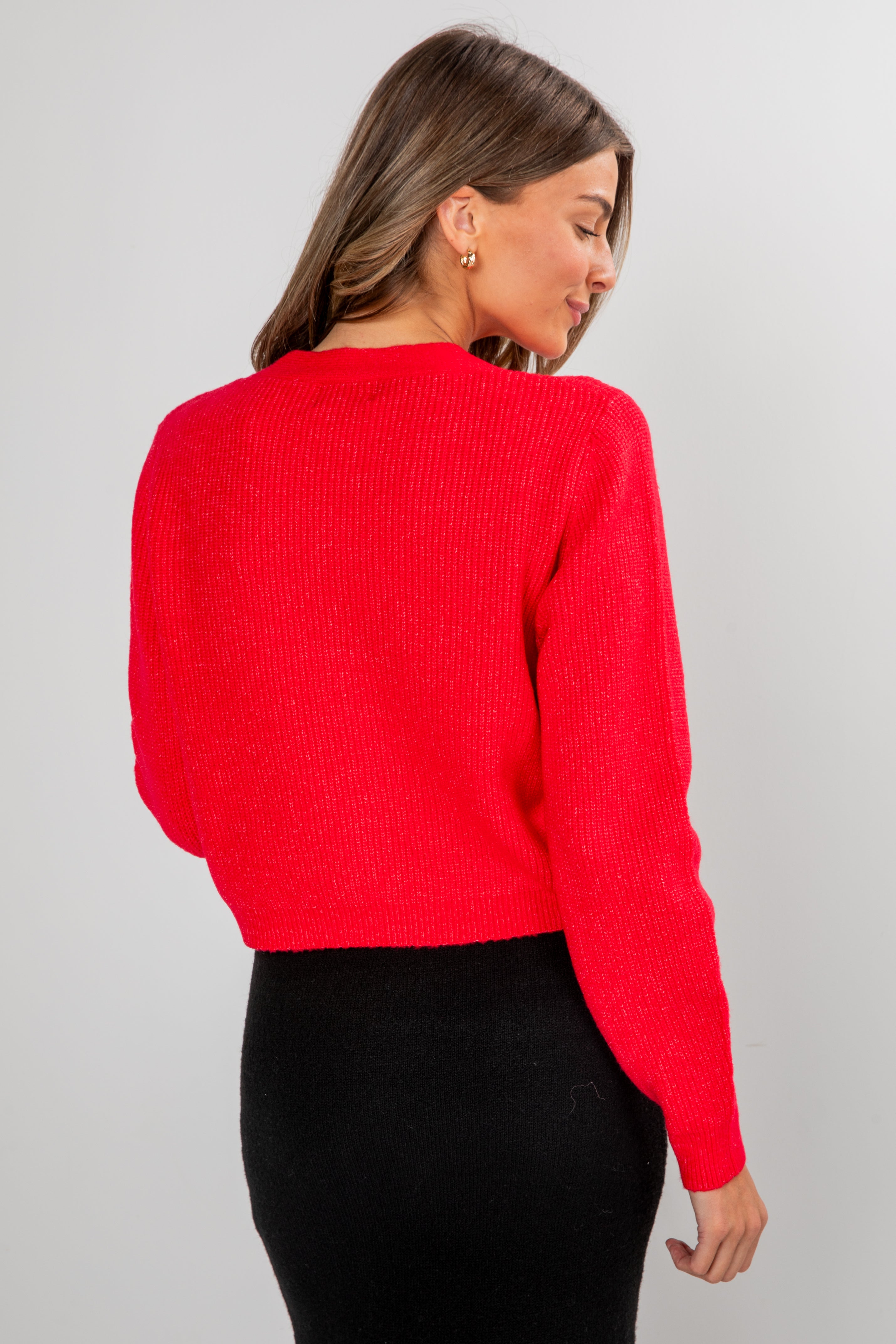 Woman wearing a red sweater against a gray background